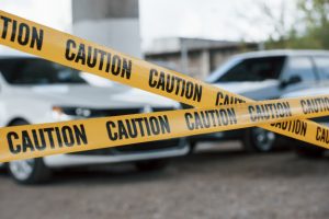 black-white-vehicles-yellow-caution-tape-near-car-parking-lot-daytime-crime-scene_146671-16659