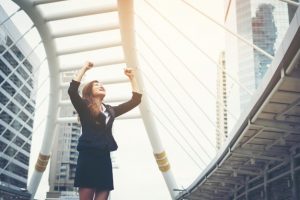 happy-success-businesswoman-overlooking-into-the-city-center-hands-raised_1150-2517
