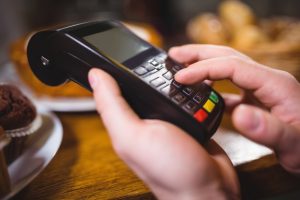 customer-making-payment-through-payment-terminal-at-counter_1170-617