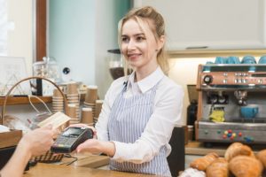 cashier-waiter-holding-credit-card-swipe-machine-while-customer-showing-credit-card-coffee-shop_23-2148028026