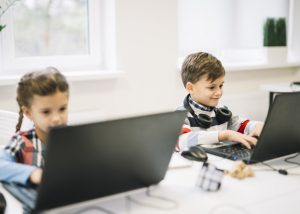 children-computer-using-laptop-sitting-with-girl-classroom_23-2148039908